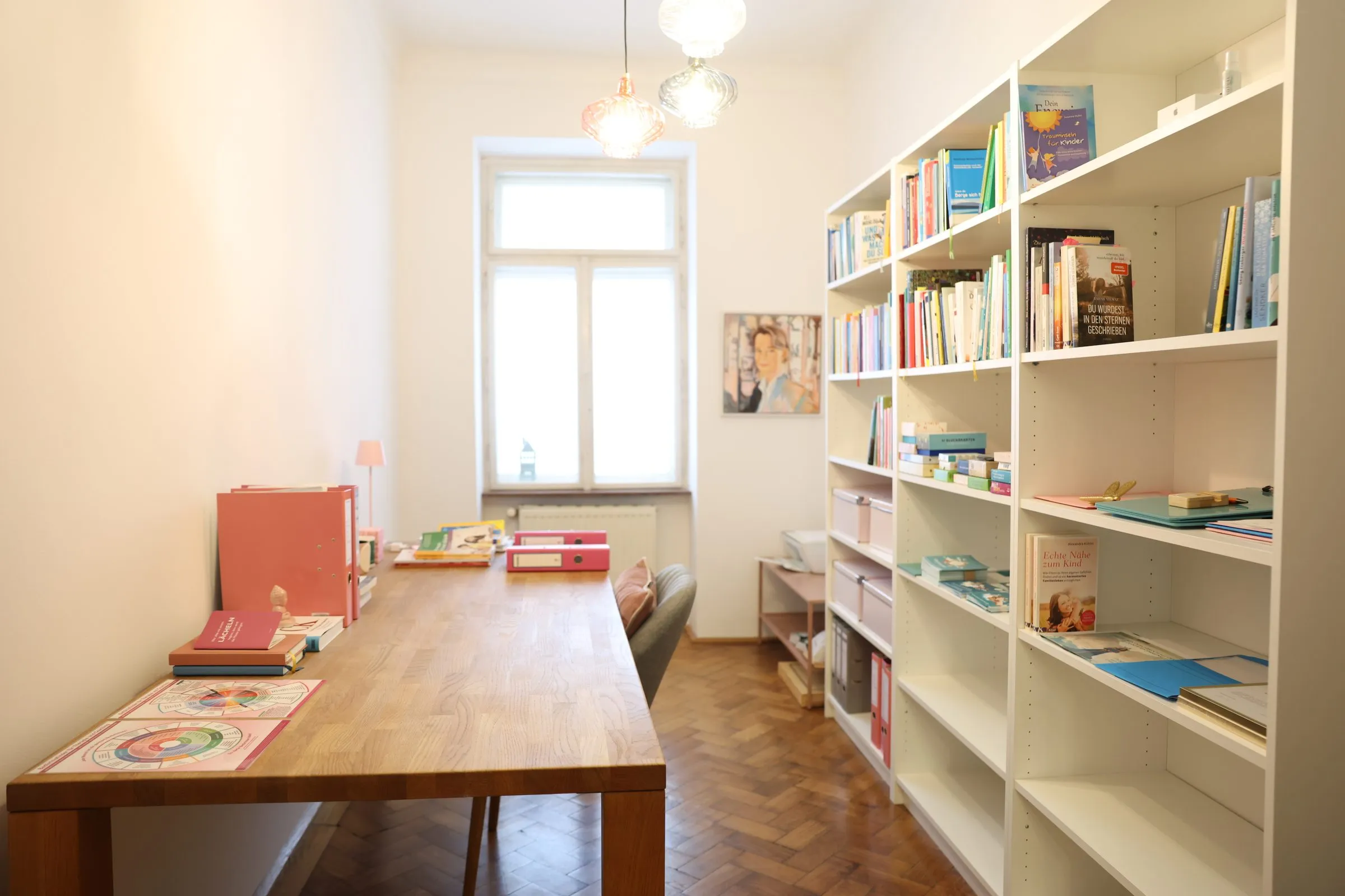 Arbeitsraum mit langem Holztisch und Bücherregal