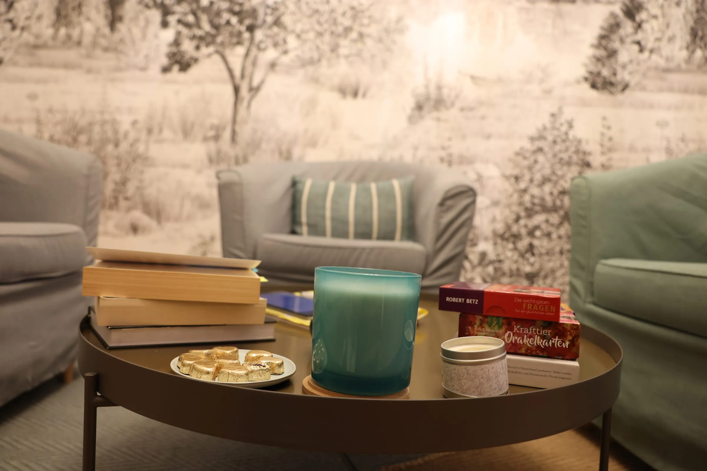 Couchtisch im Glücksraum mit Büchern, Kerze und Pralinen