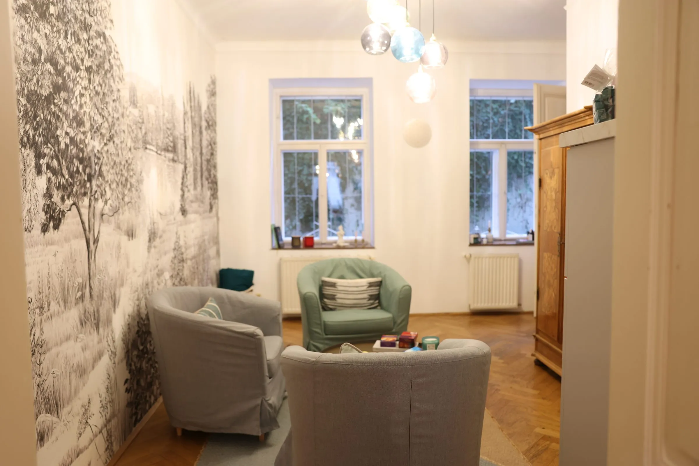Blick in den Glücksraum mit hohen Fenstern und Sesseln